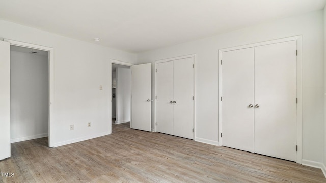 550 Pine Ridge Pl, Raleigh, NC 27609 - unfurnished bedroom with multiple closets and light wood-style floors