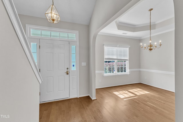 5513 Enoree Ln, Raleigh, NC 27616 - entrance foyer with a chandelier, wood finished floors, crown molding, and a raised ceiling