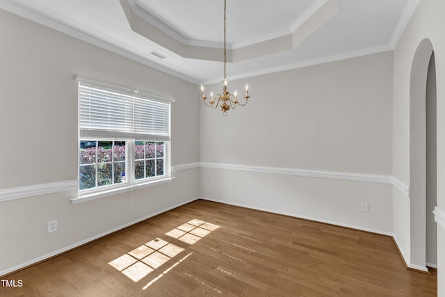 5513 Enoree Ln, Raleigh, NC 27616 - empty room featuring a chandelier, a raised ceiling, wood finished floors, crown molding, and arched walkways