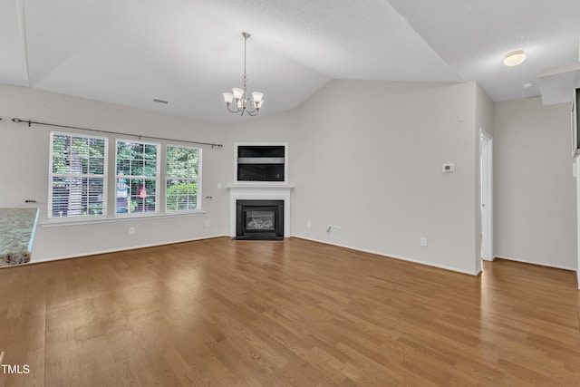 5513 Enoree Ln, Raleigh, NC 27616 - unfurnished living room featuring vaulted ceiling, light wood-style floors, a fireplace with flush hearth, and a chandelier