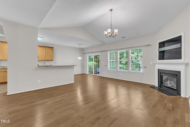 5513 Enoree Ln, Raleigh, NC 27616 - unfurnished living room with a fireplace with flush hearth, wood finished floors, a chandelier, and lofted ceiling