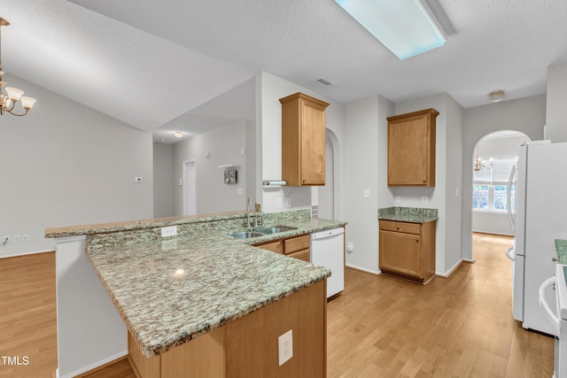 5513 Enoree Ln, Raleigh, NC 27616 - kitchen featuring white appliances, arched walkways, a peninsula, a chandelier, and a textured ceiling