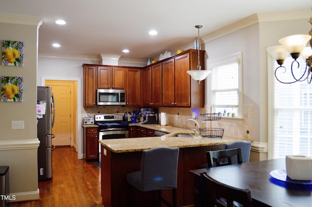 114 Bridle Path, Pittsboro, NC 27312 - kitchen with appliances with stainless steel finishes, a peninsula, tasteful backsplash, light stone counters, and crown molding
