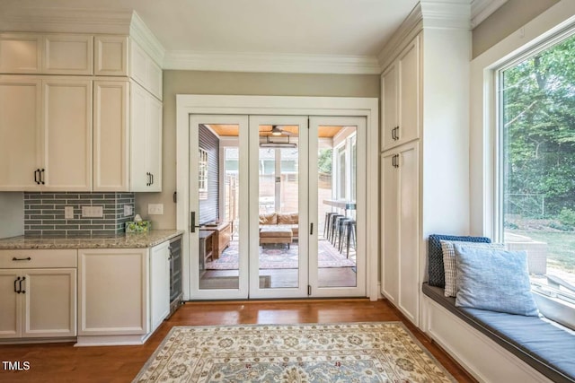 1213 Pierce St, Raleigh, NC 27605 - doorway to outside featuring wood finished floors, wine cooler, ornamental molding, and a ceiling fan