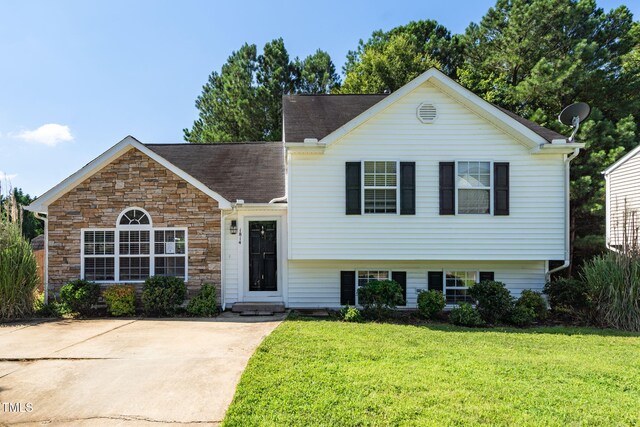 1814 Shiva Ct, Durham, NC 27703 - view of front of house with a front lawn, stone siding, and roof with shingles