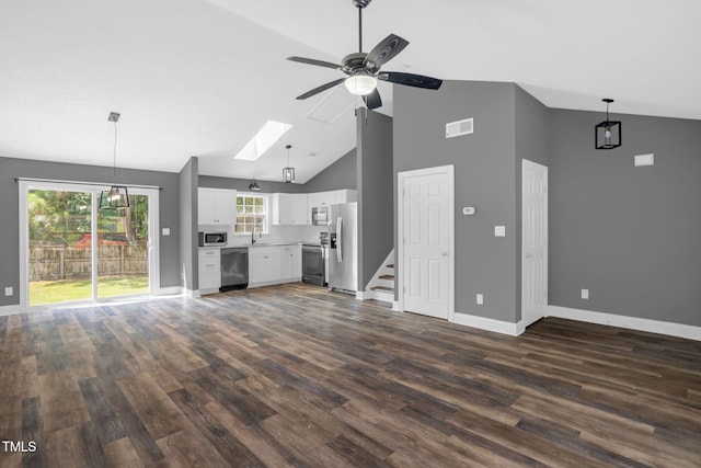 1814 Shiva Ct, Durham, NC 27703 - unfurnished living room with a ceiling fan, high vaulted ceiling, a skylight, dark wood-style floors, and stairs