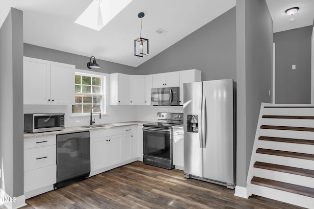 1814 Shiva Ct, Durham, NC 27703 - kitchen with stainless steel appliances, a skylight, tasteful backsplash, white cabinets, and lofted ceiling