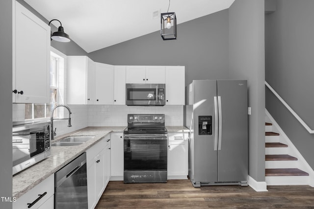 1814 Shiva Ct, Durham, NC 27703 - kitchen with stainless steel appliances, vaulted ceiling, tasteful backsplash, white cabinetry, and light stone counters