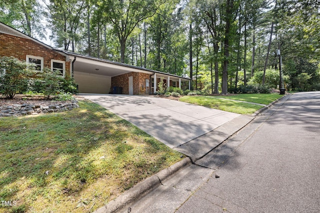 700 Tinkerbell Rd, Chapel Hill, NC 27517 - view of front of property with concrete driveway, an attached carport, a front lawn, and brick siding