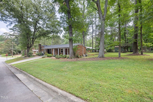 700 Tinkerbell Rd, Chapel Hill, NC 27517 - view of front of house featuring a front lawn, concrete driveway, brick siding, and a chimney