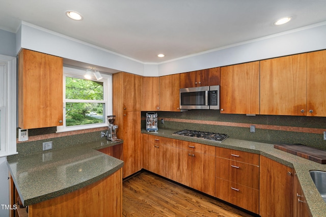 700 Tinkerbell Rd, Chapel Hill, NC 27517 - kitchen with appliances with stainless steel finishes, brown cabinetry, tasteful backsplash, dark wood finished floors, and dark stone counters