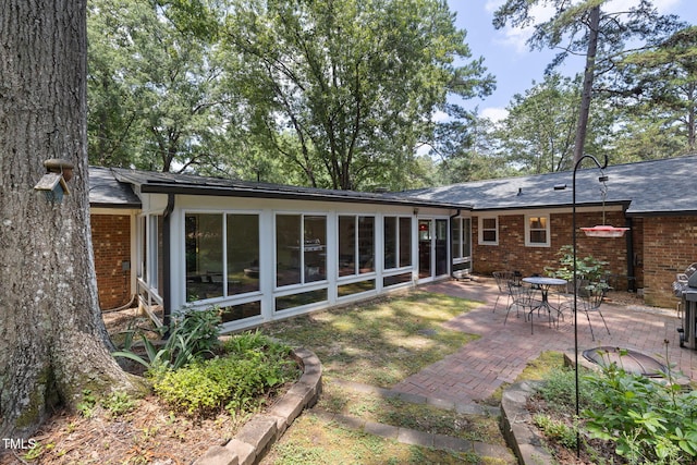 700 Tinkerbell Rd, Chapel Hill, NC 27517 - rear view of property featuring a sunroom, a patio area, and brick siding