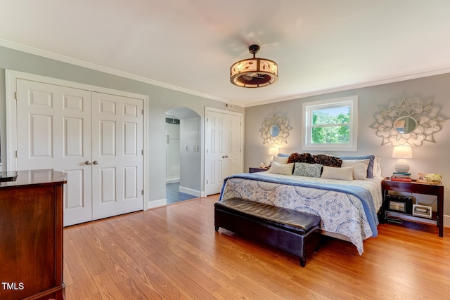 10781 US-158, Reidsville, NC 27320 - bedroom with arched walkways, multiple closets, light wood-style floors, crown molding, and ensuite bath
