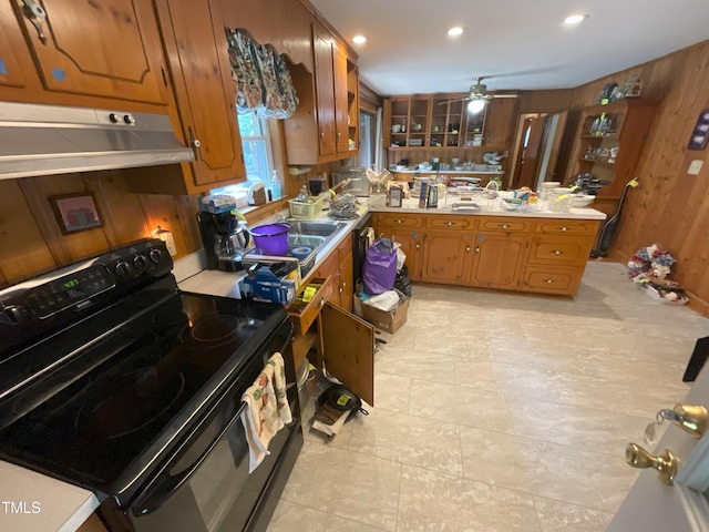 5924 Woodcrest Dr, Raleigh, NC 27603 - kitchen featuring black range with electric stovetop, light countertops, under cabinet range hood, brown cabinetry, and ceiling fan