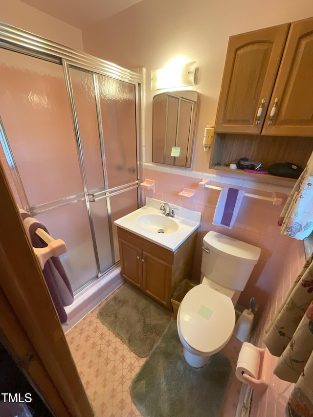 5924 Woodcrest Dr, Raleigh, NC 27603 - bathroom with a stall shower, vanity, tile walls, and tile patterned floors