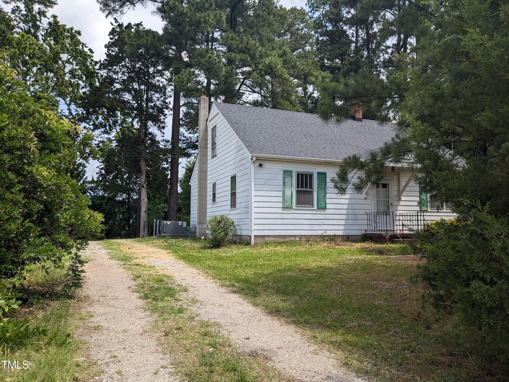 4503 Hopson Rd, Morrisville, NC 27560 - view of front facade featuring a chimney, dirt driveway, a shingled roof, and a front yard