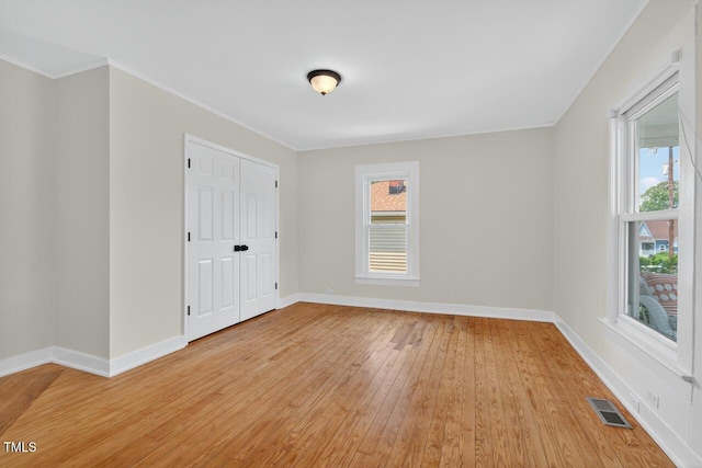 1001 Lancaster St, Durham, NC 27701 - unfurnished bedroom featuring light wood-style floors, ornamental molding, and a closet