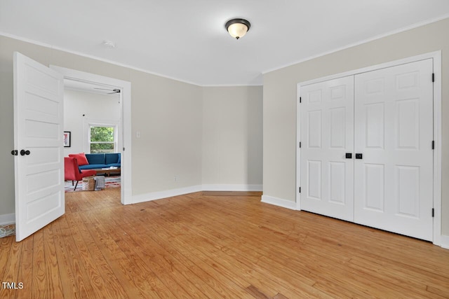1001 Lancaster St, Durham, NC 27701 - unfurnished bedroom featuring light wood-type flooring, ornamental molding, and a closet