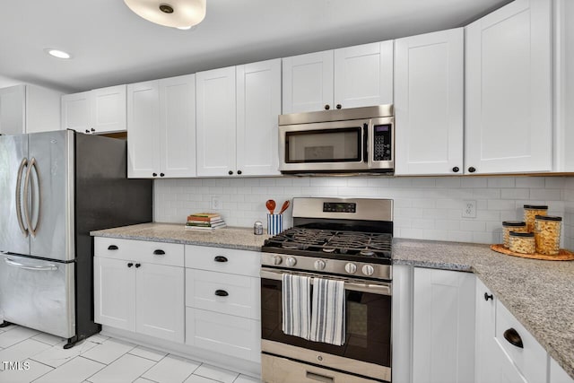 1001 Lancaster St, Durham, NC 27701 - kitchen featuring stainless steel appliances, white cabinets, backsplash, light stone countertops, and recessed lighting