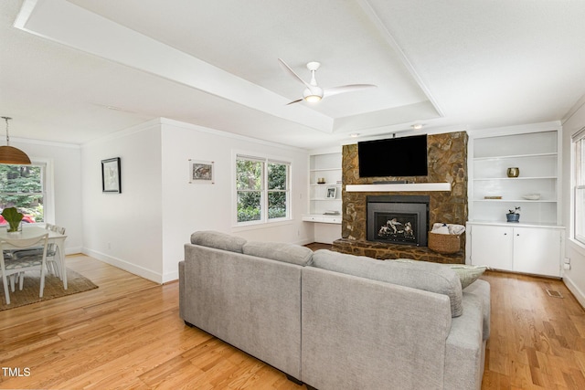 6025 Tarnhour Ct, Raleigh, NC 27612 - living area featuring a fireplace, light wood-style flooring, built in features, ceiling fan, and crown molding