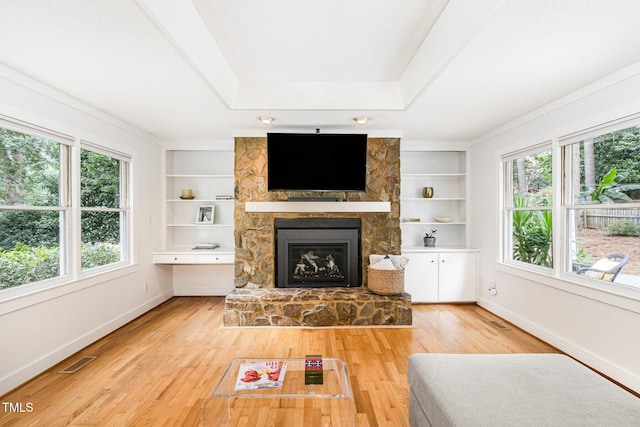 6025 Tarnhour Ct, Raleigh, NC 27612 - unfurnished living room featuring a stone fireplace, built in shelves, and light wood-style flooring