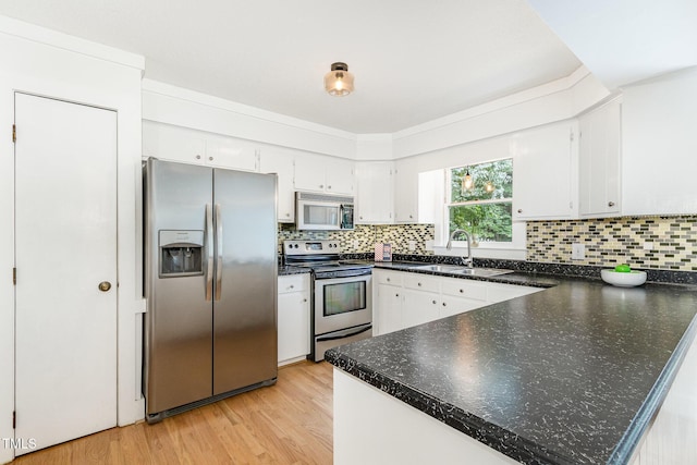 6025 Tarnhour Ct, Raleigh, NC 27612 - kitchen with appliances with stainless steel finishes, a peninsula, light wood-style flooring, white cabinetry, and backsplash