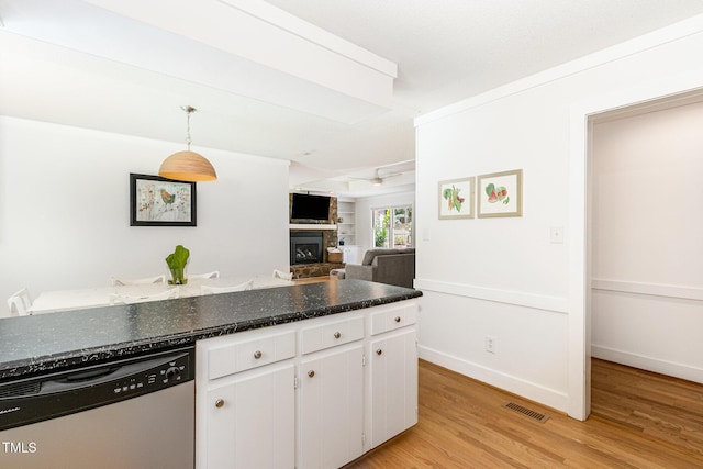6025 Tarnhour Ct, Raleigh, NC 27612 - kitchen featuring dishwasher, light wood finished floors, a fireplace, white cabinets, and pendant lighting