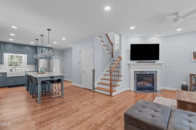 511 Scotts Ridge Trl, Apex, NC 27502 - living area featuring stairway, a high end fireplace, light wood-style floors, a ceiling fan, and recessed lighting