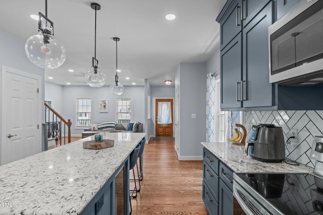 511 Scotts Ridge Trl, Apex, NC 27502 - kitchen featuring stainless steel appliances, decorative backsplash, recessed lighting, light stone countertops, and light wood-style flooring