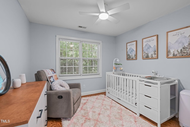 511 Scotts Ridge Trl, Apex, NC 27502 - bedroom with a crib, wood finished floors, and a ceiling fan