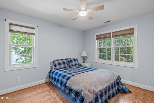 511 Scotts Ridge Trl, Apex, NC 27502 - bedroom with multiple windows, wood finished floors, and ceiling fan