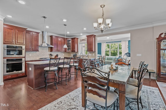 1950 Firenza Dr, Apex, NC 27502 - dining space with ornamental molding, a chandelier, dark wood-style flooring, and recessed lighting