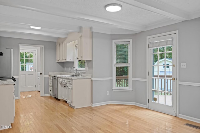 3104 Braywood Ct, Apex, NC 27539 - kitchen with beamed ceiling, light countertops, white cabinets, light wood-type flooring, and stainless steel dishwasher