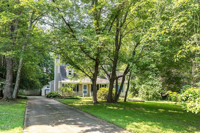 3104 Braywood Ct, Apex, NC 27539 - view of front of house featuring covered porch, a storage unit, a front lawn, a chimney, and asphalt driveway