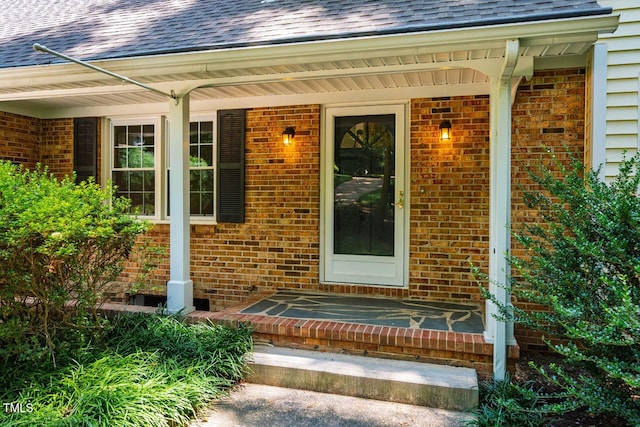 2330 Thunder Rd, Durham, NC 27712 - property entrance with a shingled roof, a porch, and brick siding