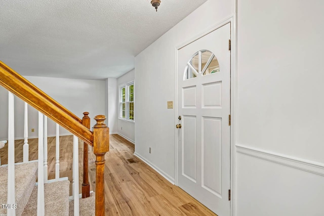 2330 Thunder Rd, Durham, NC 27712 - foyer entrance with light wood-style floors, a textured ceiling, and stairway