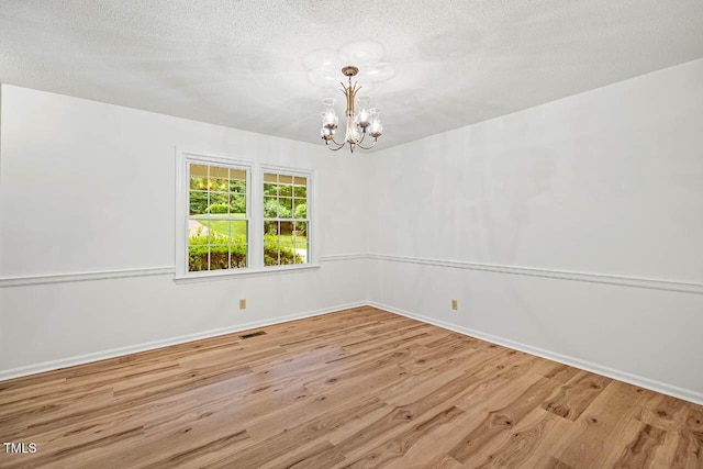2330 Thunder Rd, Durham, NC 27712 - spare room with wood finished floors, a chandelier, and a textured ceiling
