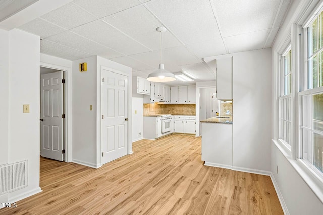 2330 Thunder Rd, Durham, NC 27712 - kitchen with a drop ceiling, light wood finished floors, white cabinets, backsplash, and decorative light fixtures