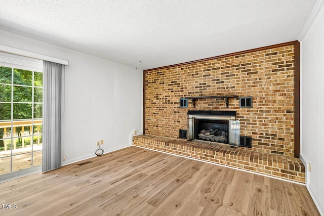 2330 Thunder Rd, Durham, NC 27712 - unfurnished living room featuring wood finished floors, a textured ceiling, a fireplace, and ornamental molding