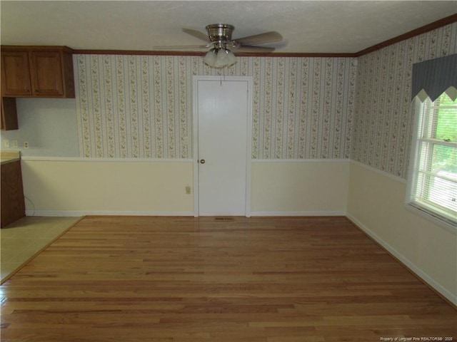 310 N Farmers Rd, Fayetteville, NC 28311 - unfurnished dining area featuring a ceiling fan, ornamental molding, light wood-type flooring, wainscoting, and wallpapered walls