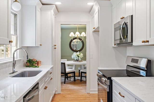 6311 Brandywine Rd, Raleigh, NC 27607 - kitchen featuring stainless steel appliances, white cabinetry, light wood-style flooring, light stone counters, and recessed lighting