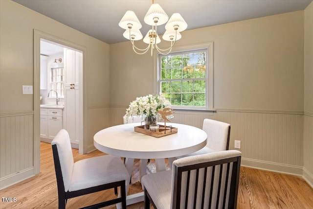 6311 Brandywine Rd, Raleigh, NC 27607 - dining area featuring wainscoting, a chandelier, and light wood-style flooring