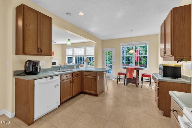 2114 Baycourt Trl, Hillsborough, NC 27278 - kitchen with white dishwasher, black microwave, brown cabinets, and a textured ceiling