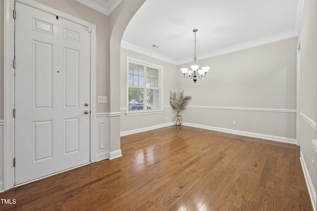 1204 Chapanoke Rd, Raleigh, NC 27603 - entrance foyer with a chandelier, ornamental molding, wood finished floors, and arched walkways