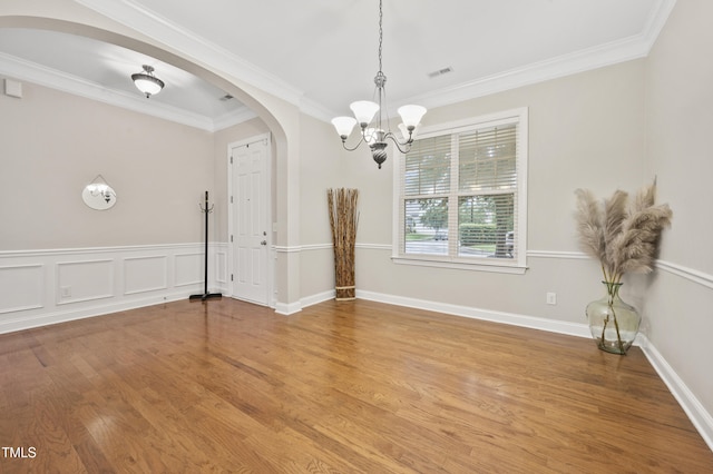 1204 Chapanoke Rd, Raleigh, NC 27603 - unfurnished dining area featuring arched walkways, a chandelier, crown molding, and wood finished floors