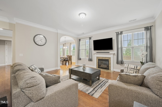 1204 Chapanoke Rd, Raleigh, NC 27603 - living room with ornamental molding, arched walkways, plenty of natural light, and light wood-style flooring