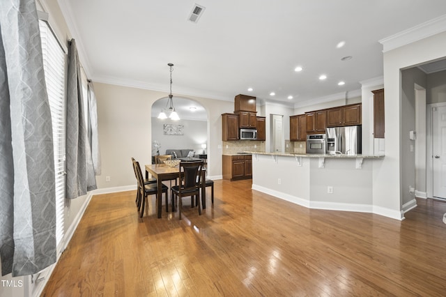 1204 Chapanoke Rd, Raleigh, NC 27603 - dining space featuring arched walkways, hardwood / wood-style flooring, recessed lighting, and crown molding