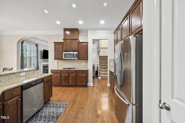 1204 Chapanoke Rd, Raleigh, NC 27603 - kitchen featuring appliances with stainless steel finishes, crown molding, tasteful backsplash, arched walkways, and recessed lighting