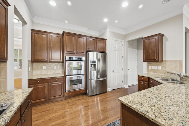 1204 Chapanoke Rd, Raleigh, NC 27603 - kitchen featuring appliances with stainless steel finishes, light stone countertops, crown molding, light wood-style floors, and recessed lighting