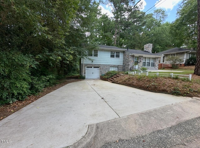 2022 Bivins St, Durham, NC 27707 - split level home featuring an attached garage, concrete driveway, a chimney, and stone siding